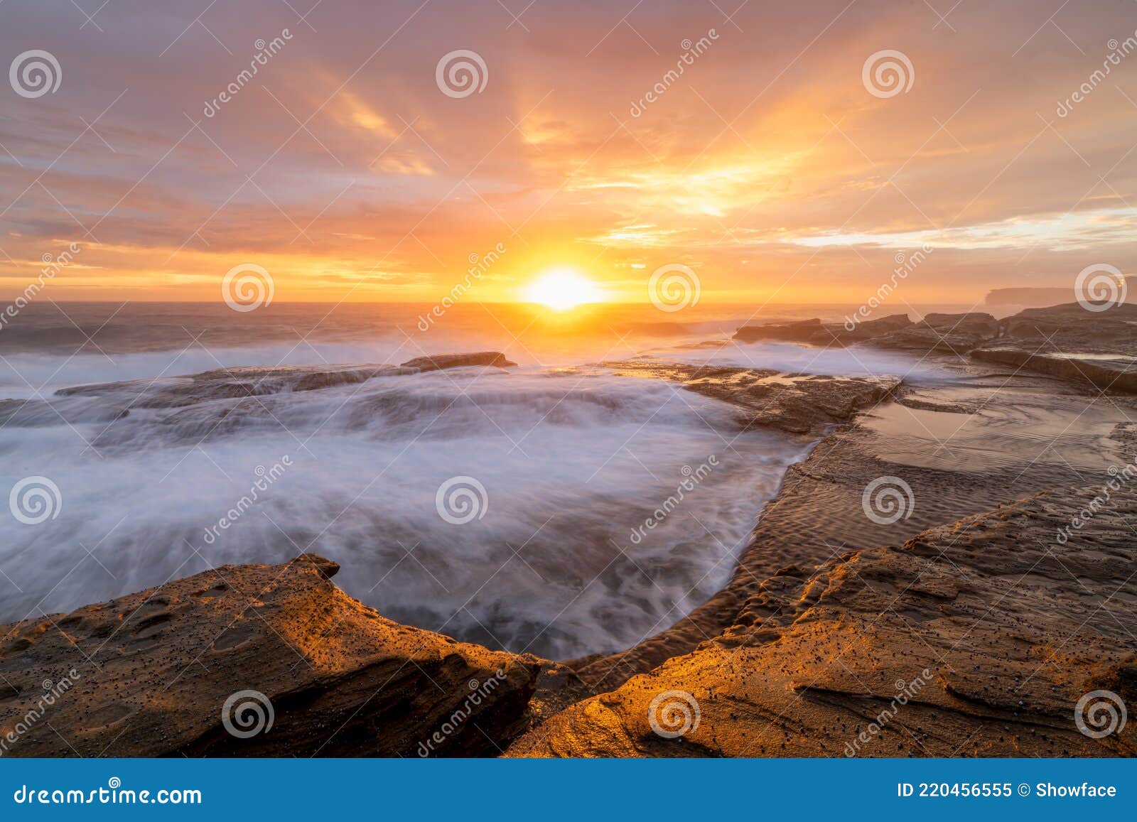 sunrays burst forth from sunrise sun on beautiful coastline