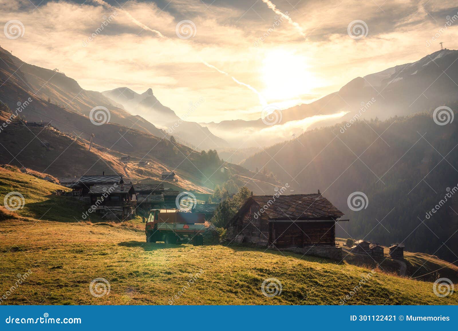sunrise over mountain and rustic village, truck on hill in countryside at switzerland