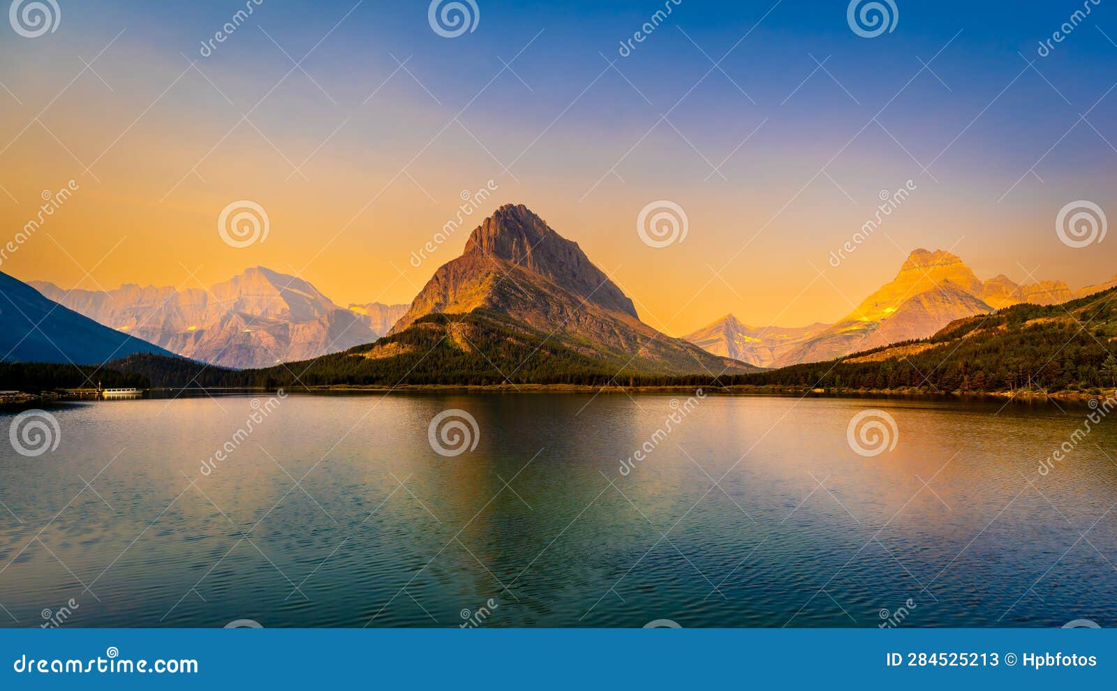 sunrise over swiftcurrent lake and grinnell point in glacier national park