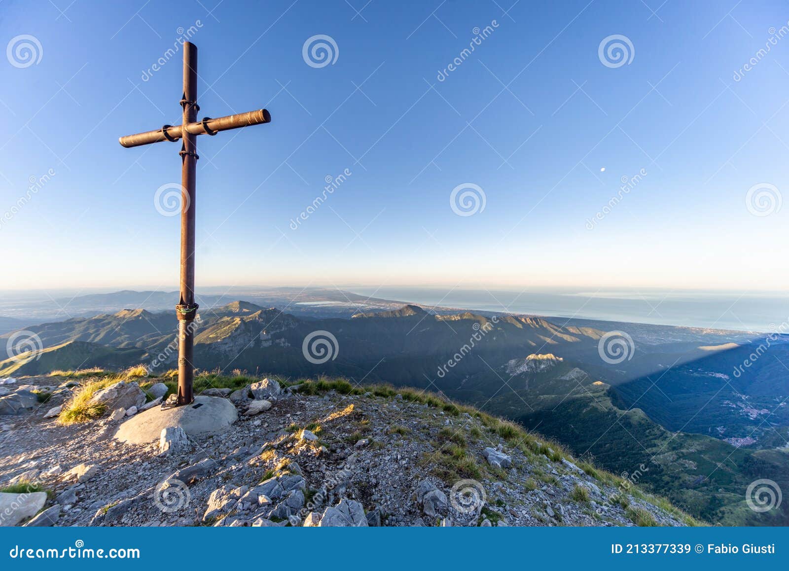 cross at sunrise on the summit of mountain peak of mount pania on the apuan alps alpi apuane, tuscany, lucca