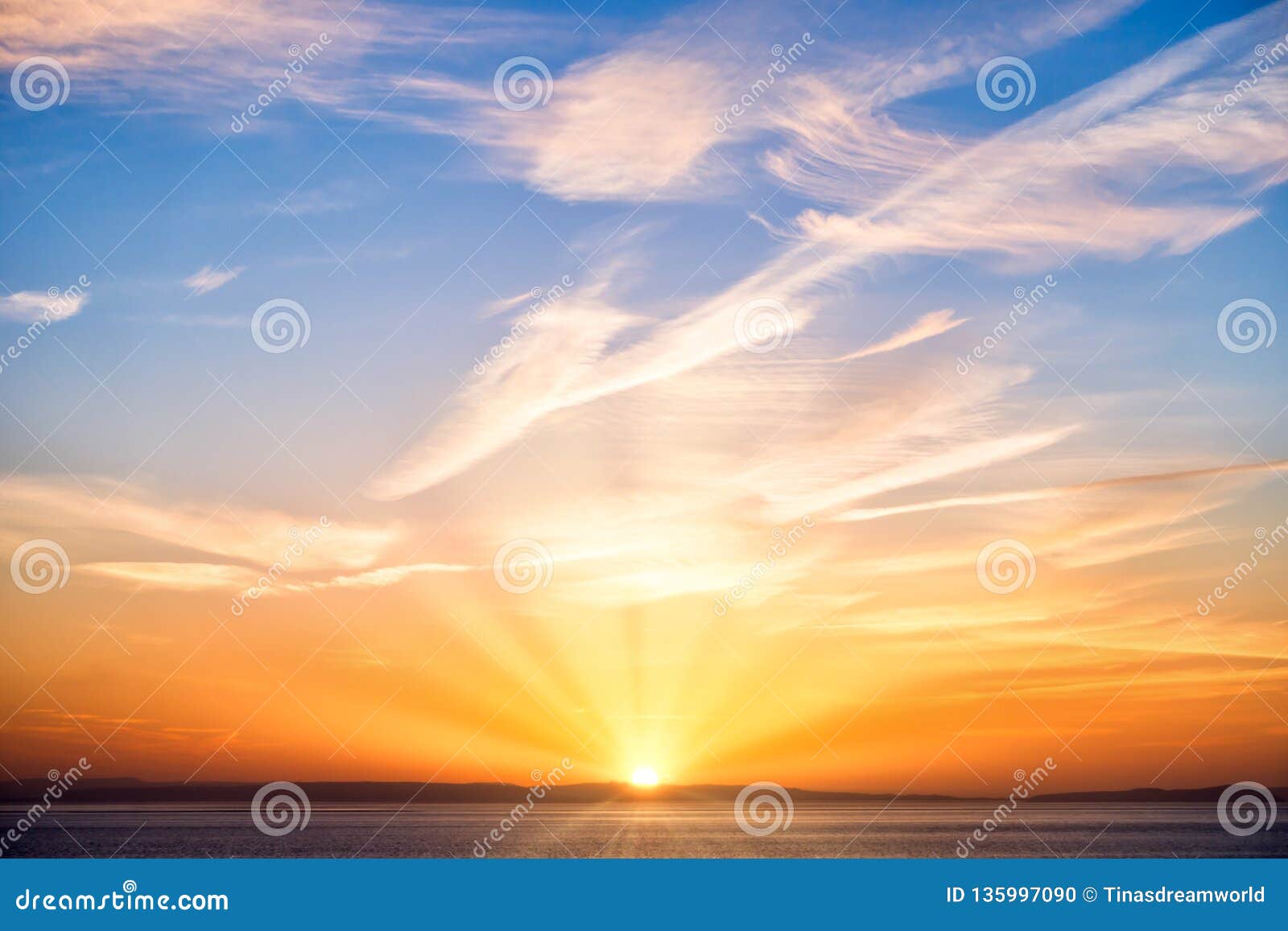 sunrise with sun, sun rays, blue sky, clouds and sea