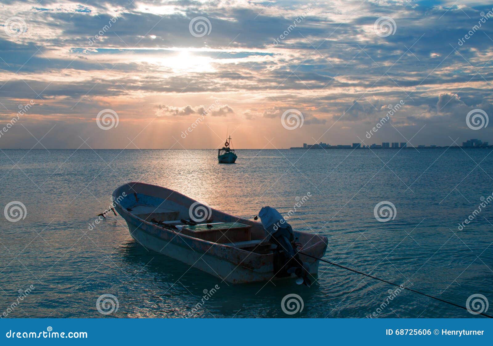sunrise view of mexican fishing boat and ponga / skiff in puerto juarez harbor of cancun bay