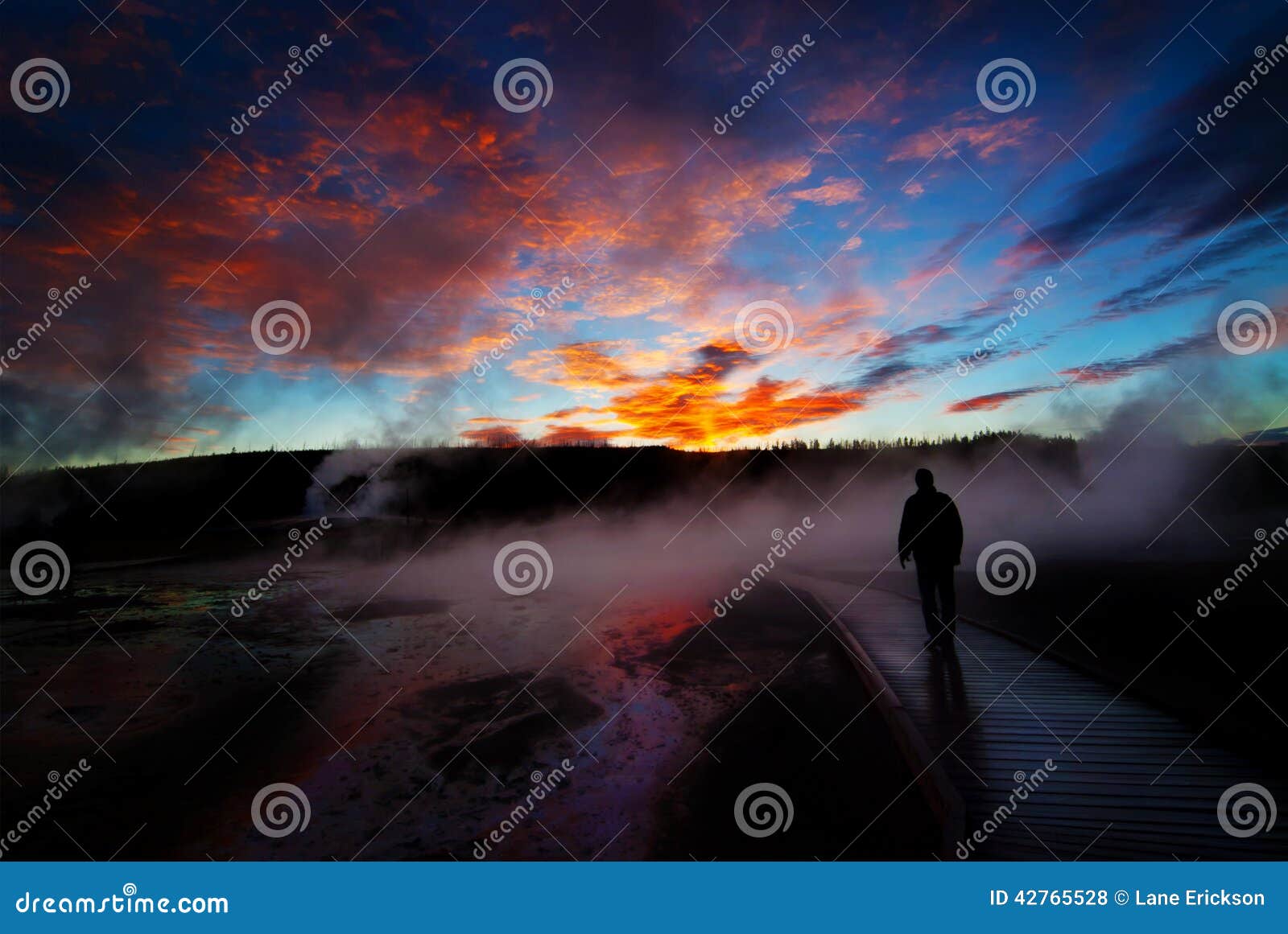 sunrise yellowstone geysers with man silhouetted