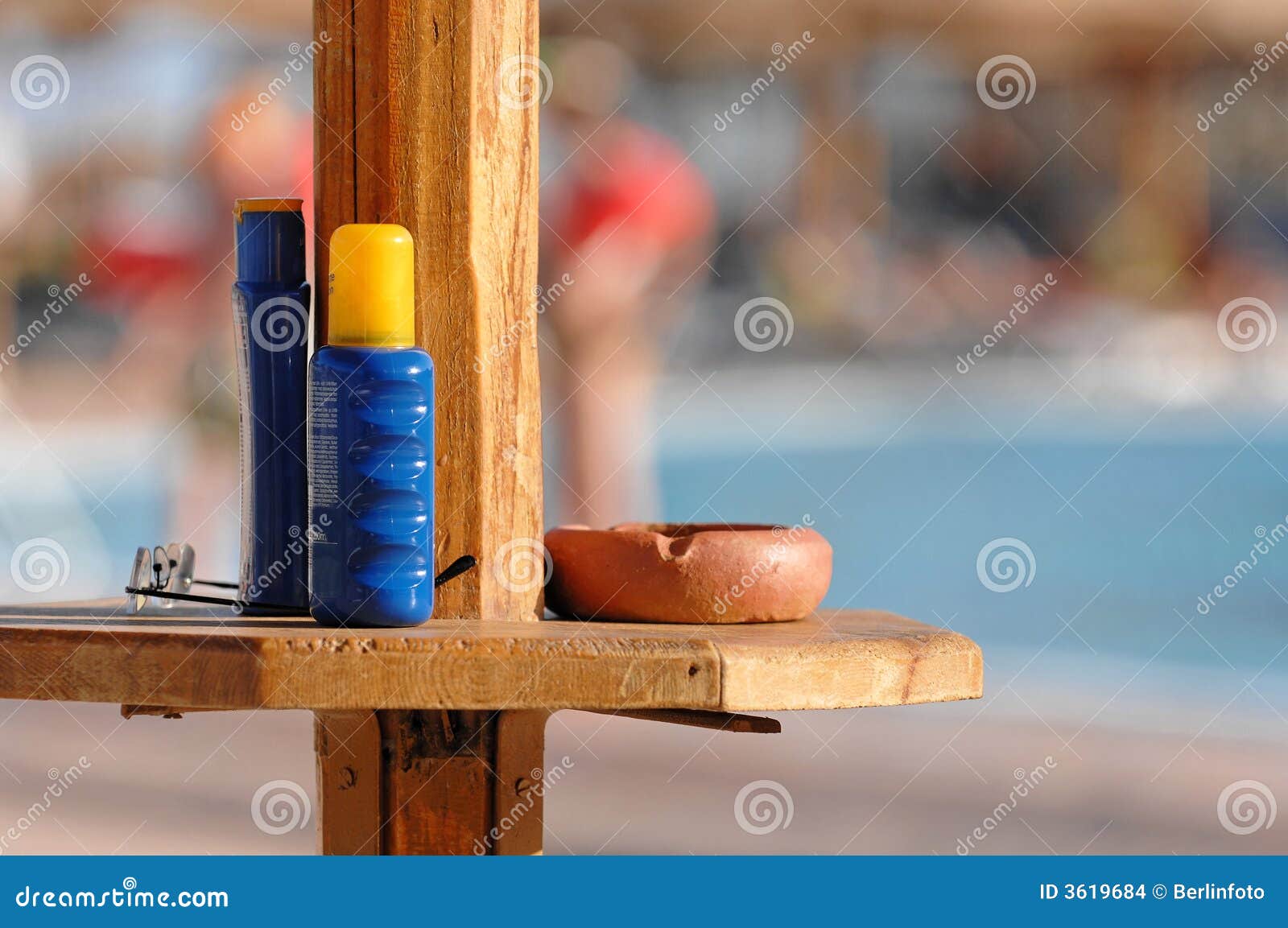 sunscreen and ashtray at pool