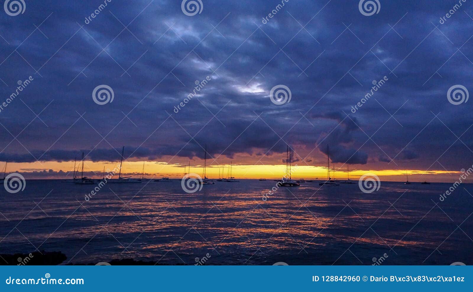 sunset on the beach with a view of the boats