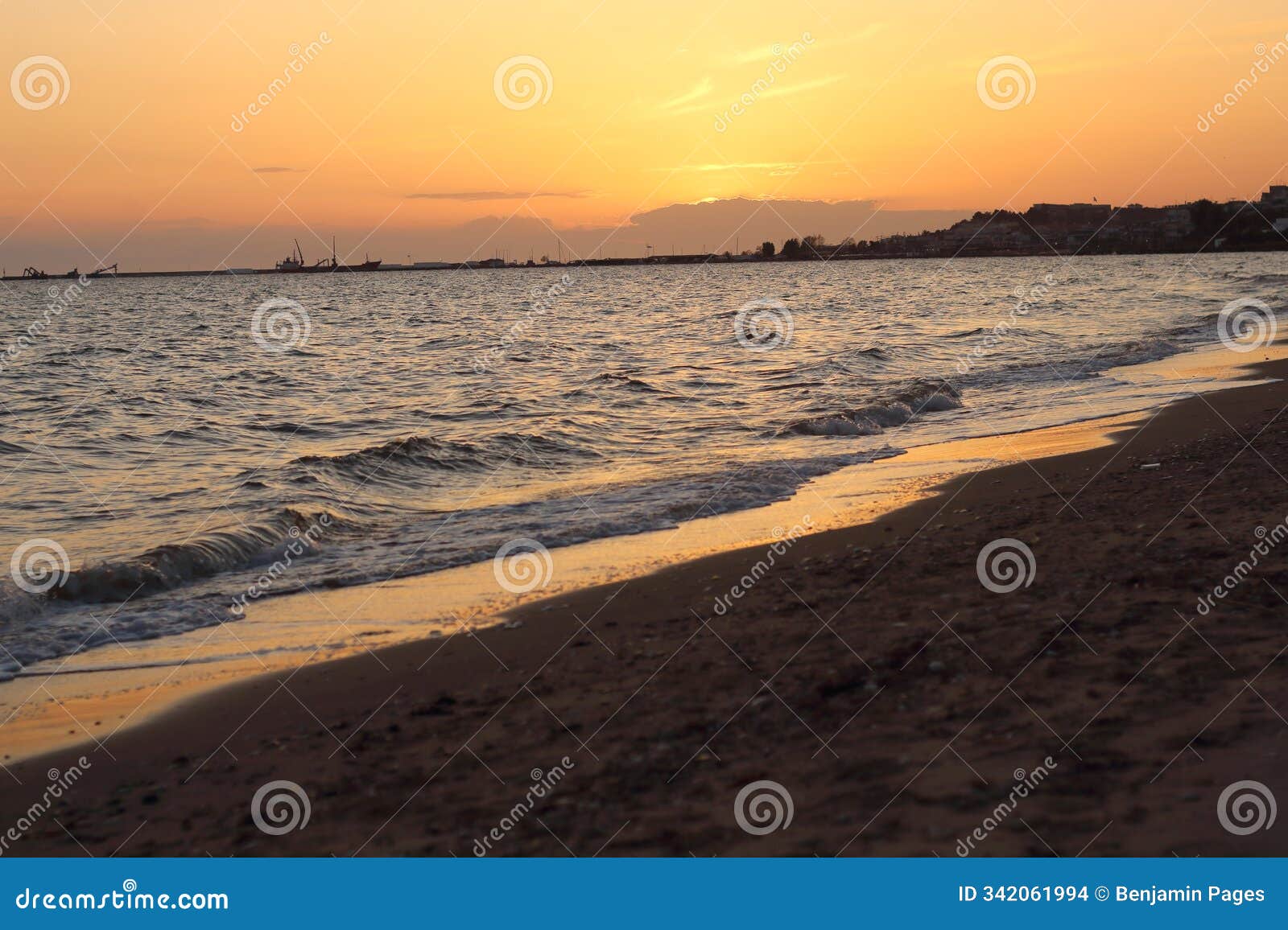 sunset casts a warm, golden glow on the sea and sand