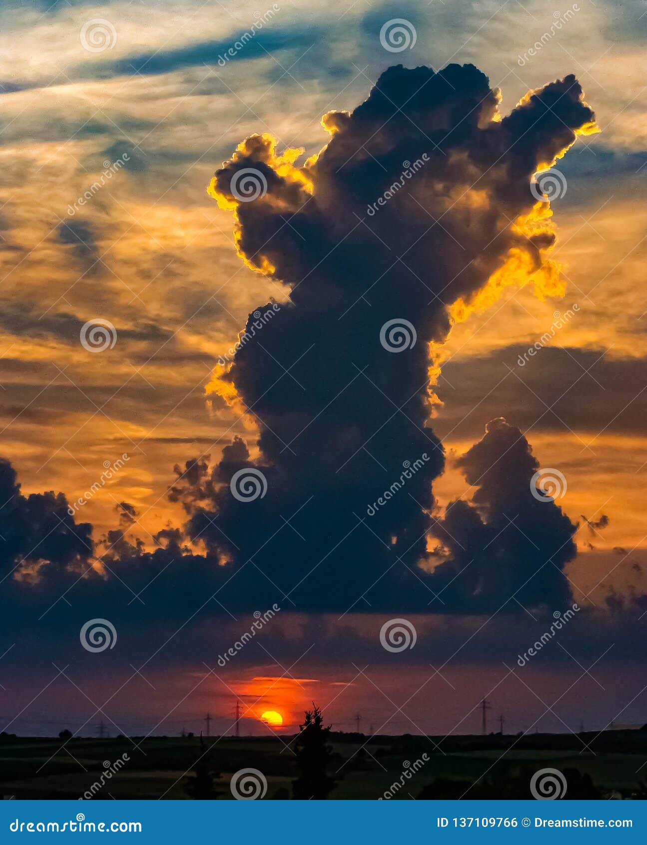 sunset with glowing sky and a tower of clouds