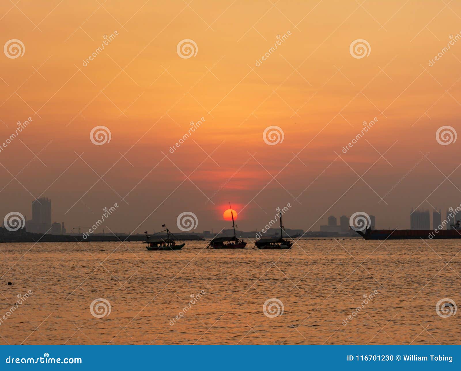 Beautiful Sunset in Jakarta with Three Boat on Ocean Stock Photo