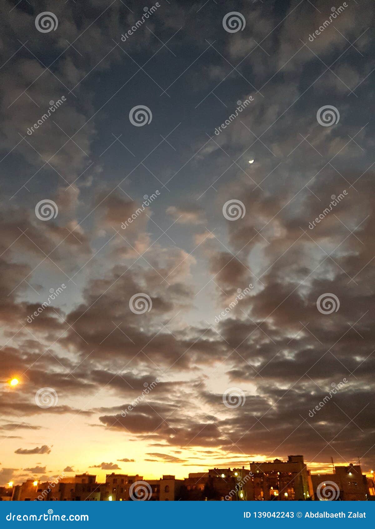sunset and moon with cloudy skies