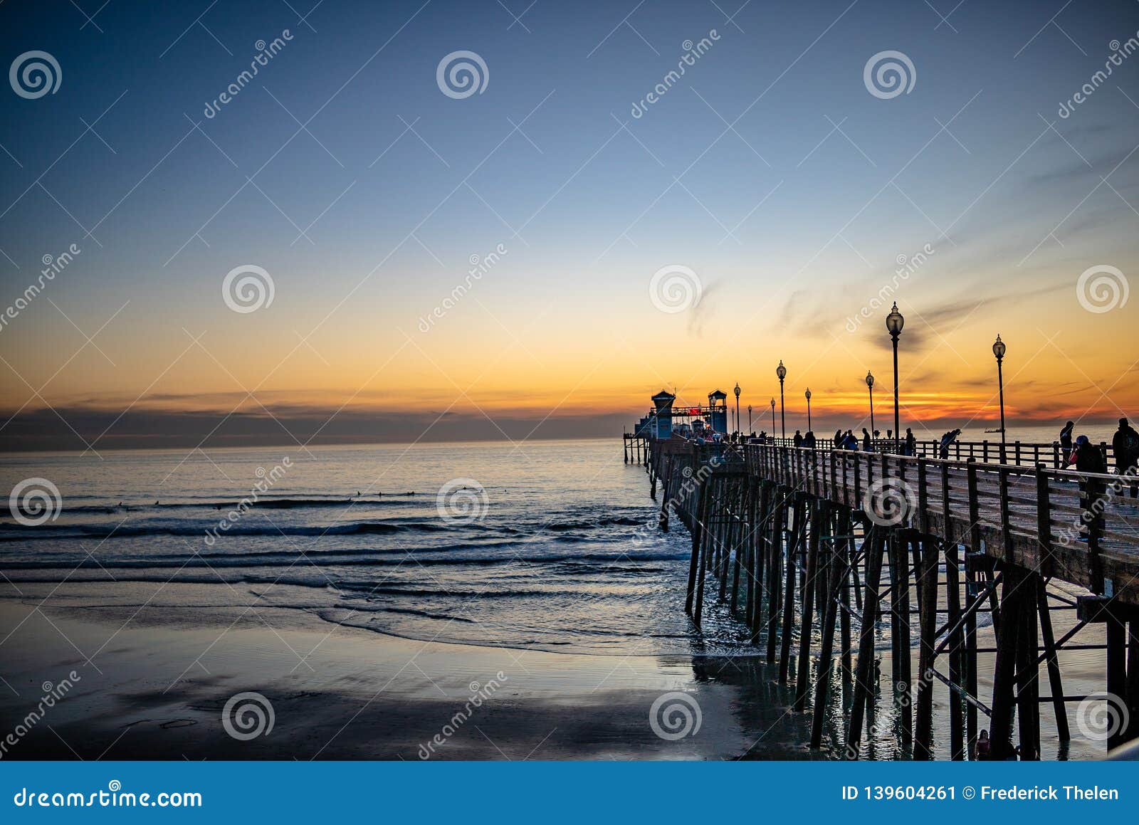 sunset by oceanside pier, palms and the pacific oceanin the famous surf city in california usa