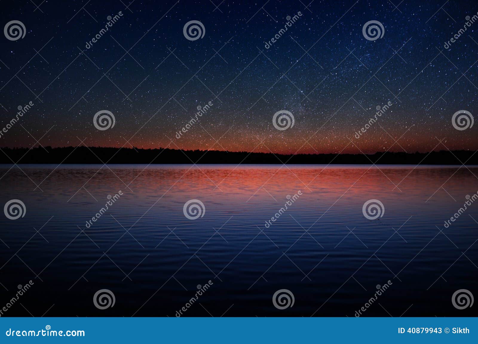 sunset over calm lake with real stars in dark sky