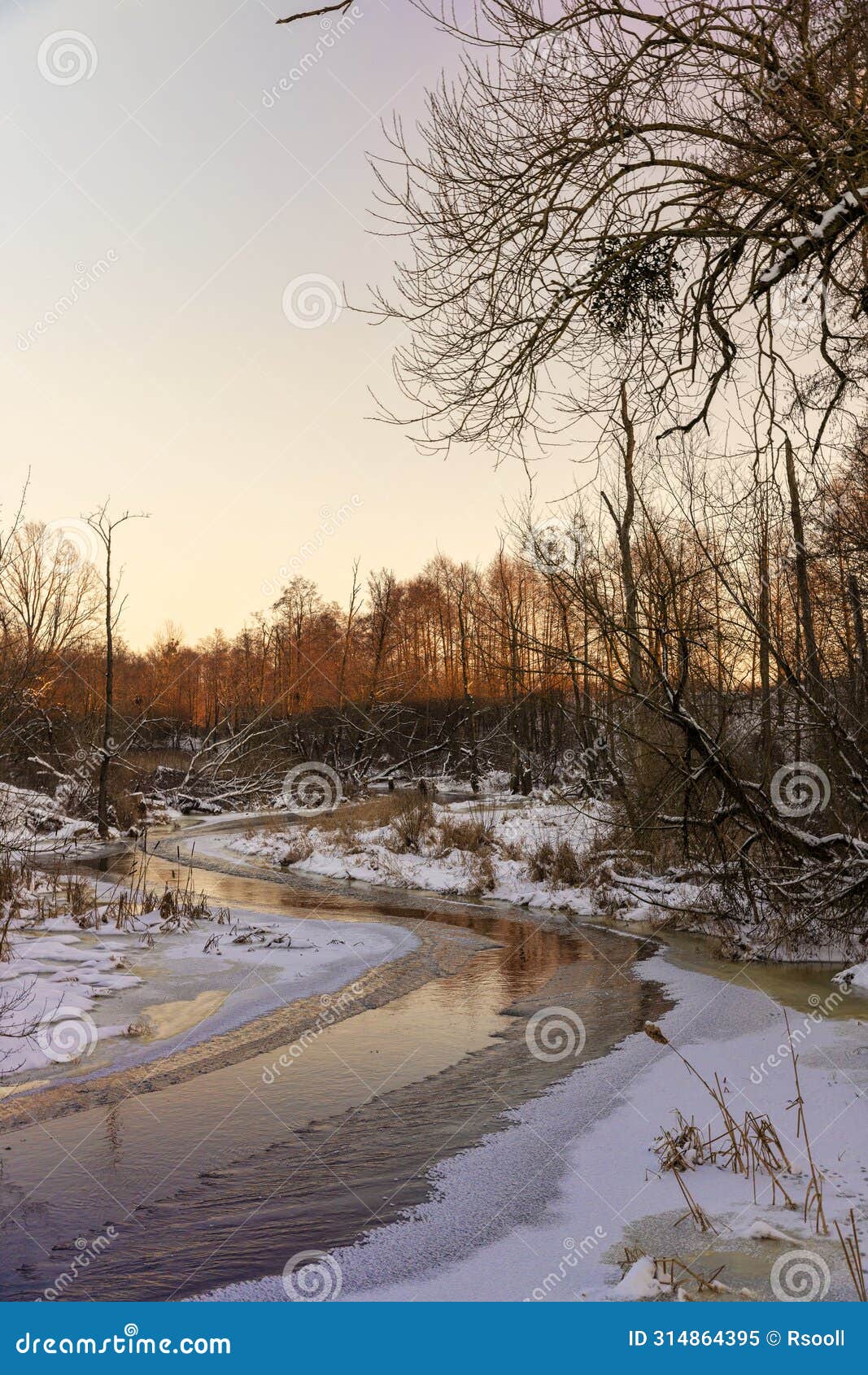sunset on a river whose banks are covered with ice