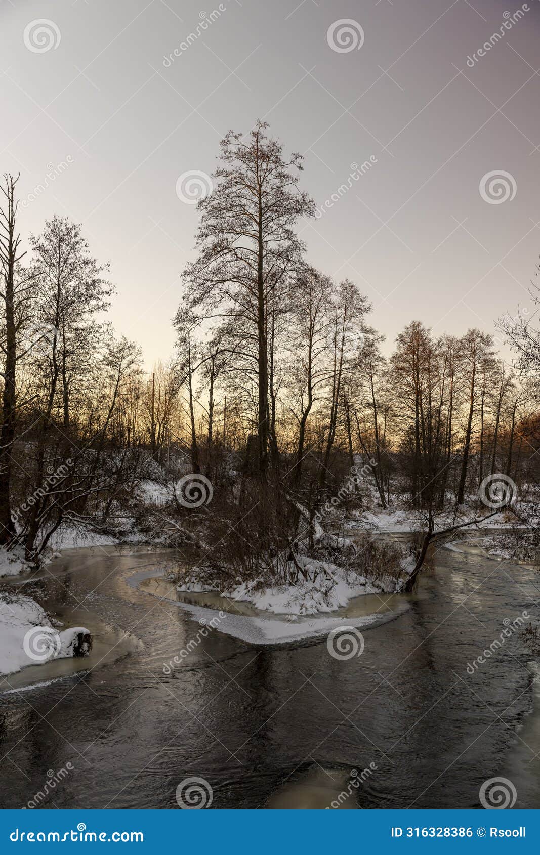 sunset on a river whose banks are covered with ice