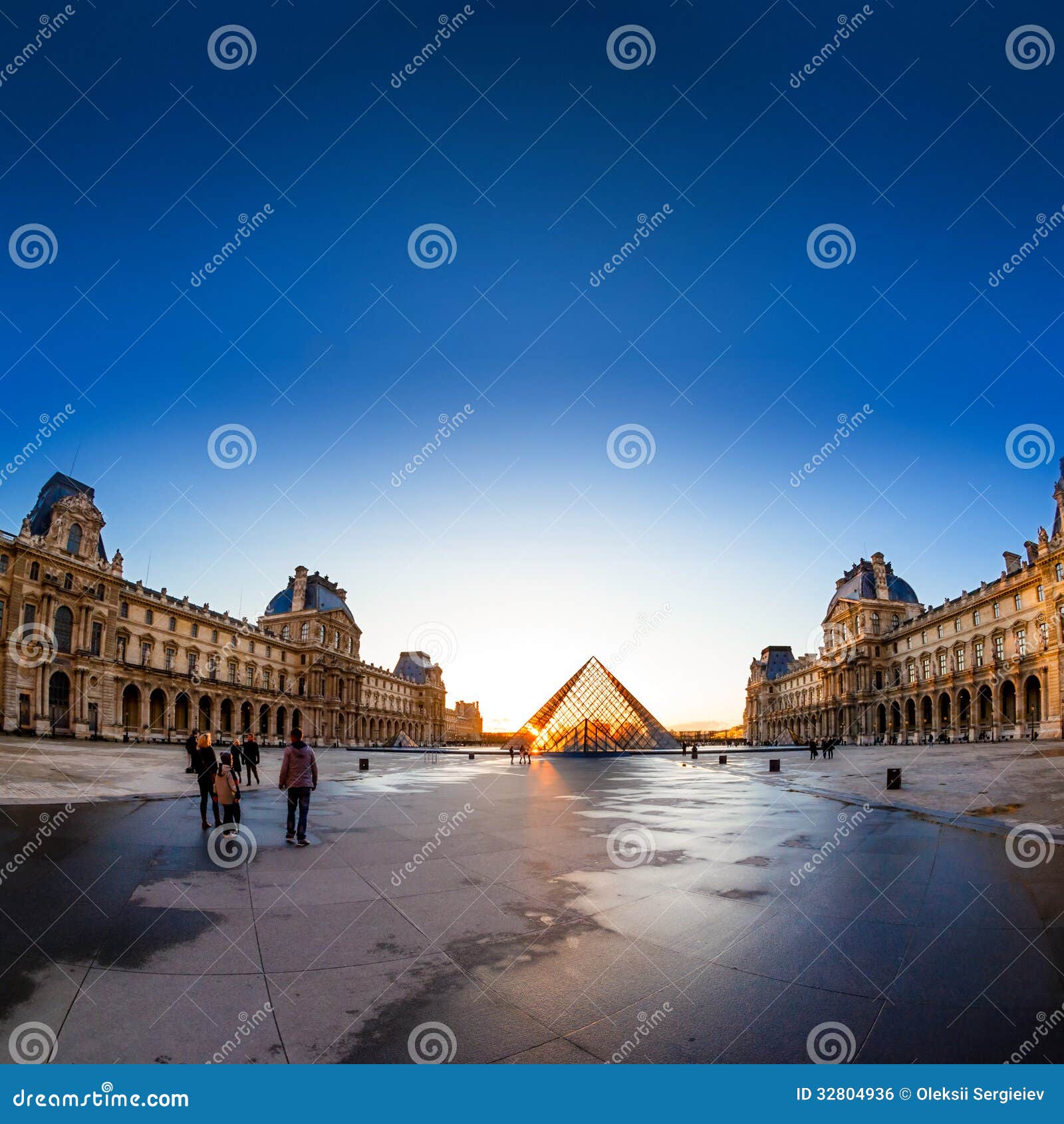 Sunset shines through the glass pyramid of the Louvre museum. PARIS, FRANCE - APRIL 12: The Louvre and pyramid during sunset on april 12, 2013 in Paris, France.