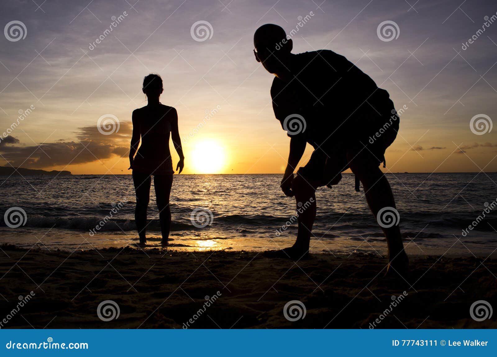 Sunset Silhouette - People. Silhouette shot of a male &amp; female figure on the beach at sunset