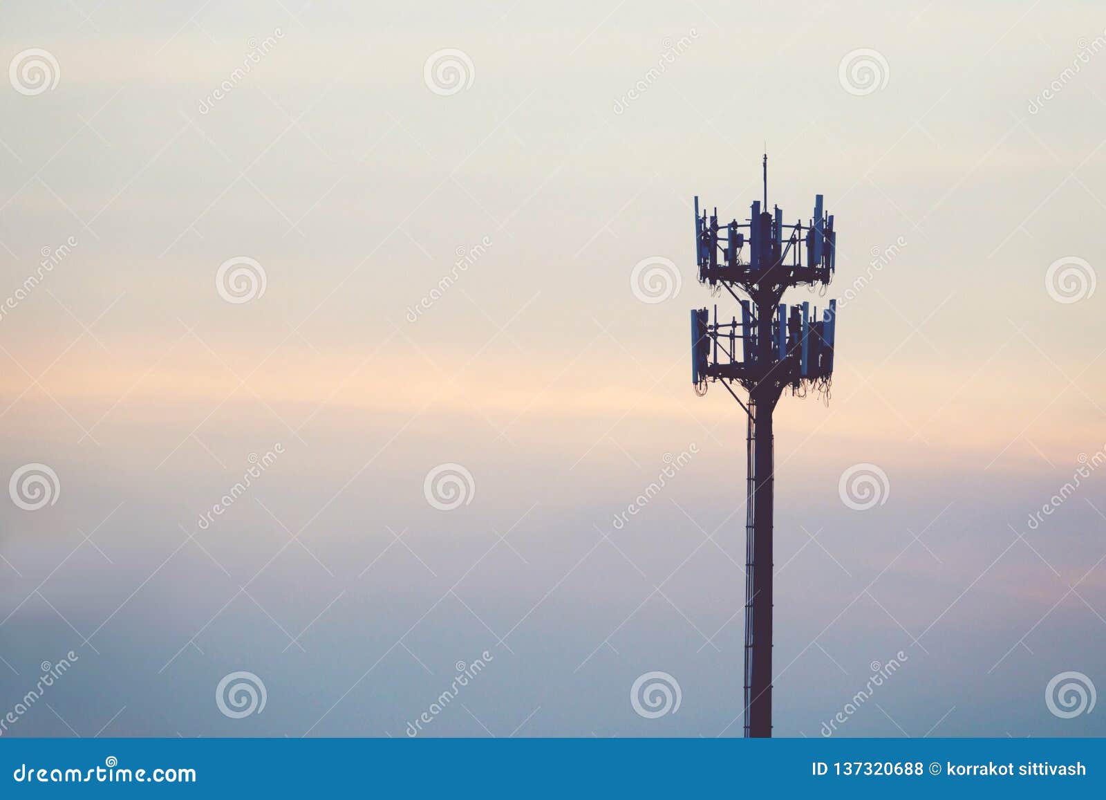 sunset and tall mast with cellular antenna