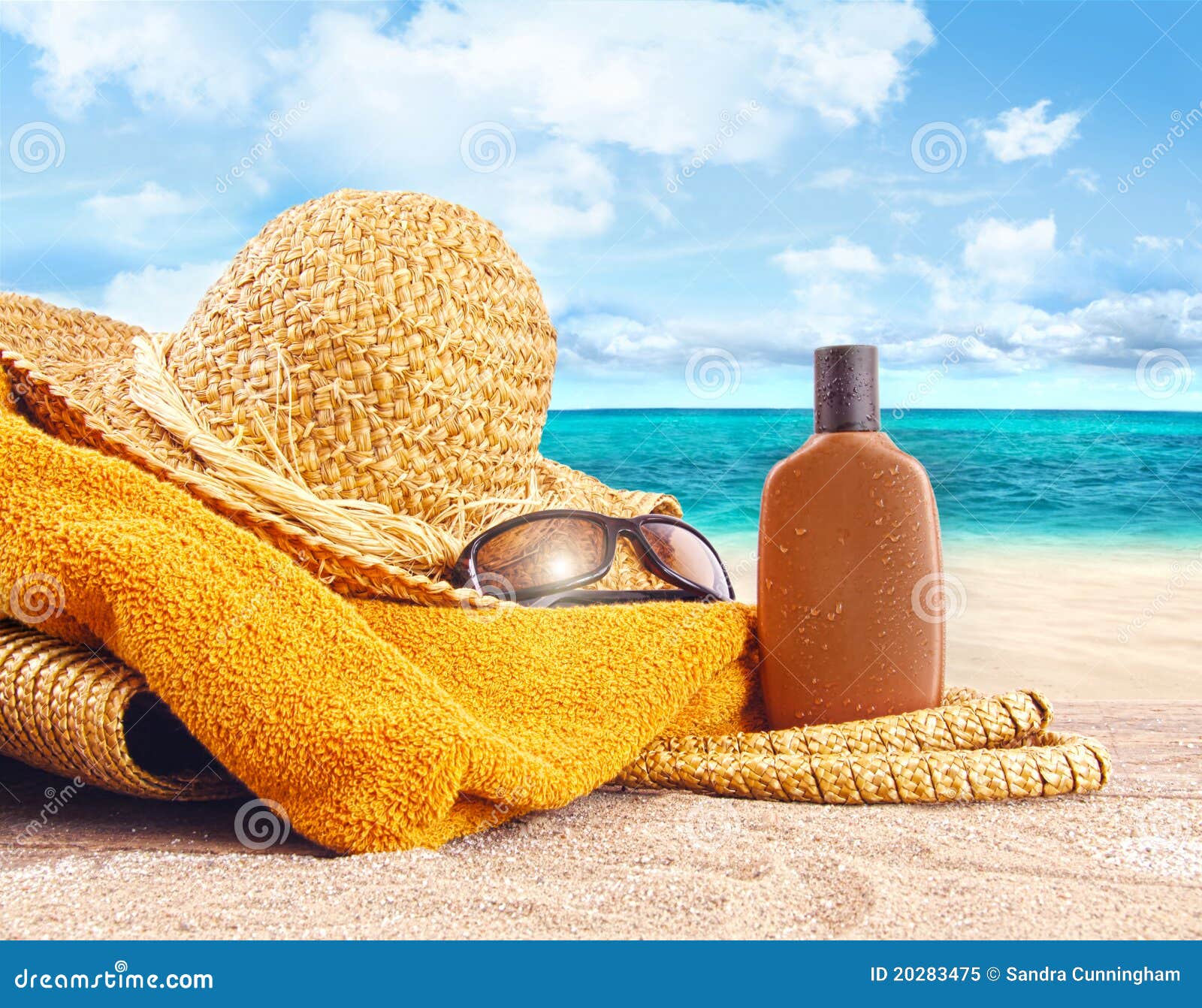 suntan lotion, straw hat at the beach