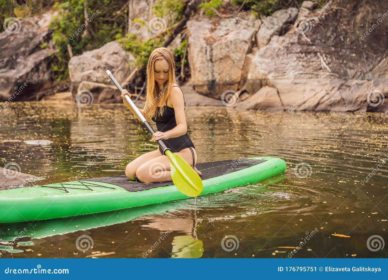 SUP Stand Up Paddle Board Woman Paddle Boarding on Lake Standing Happy