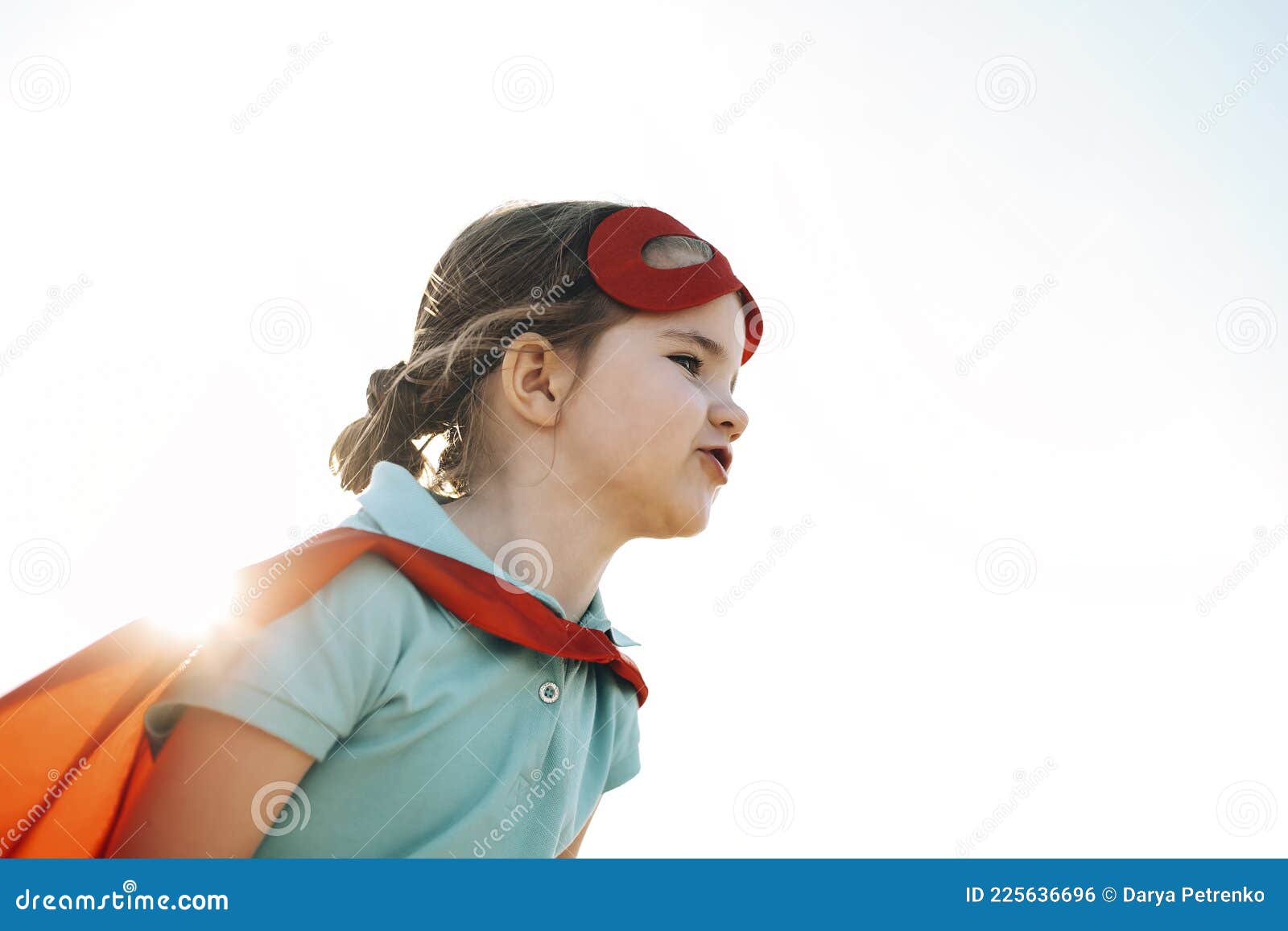 superhero kid against blue sky background
