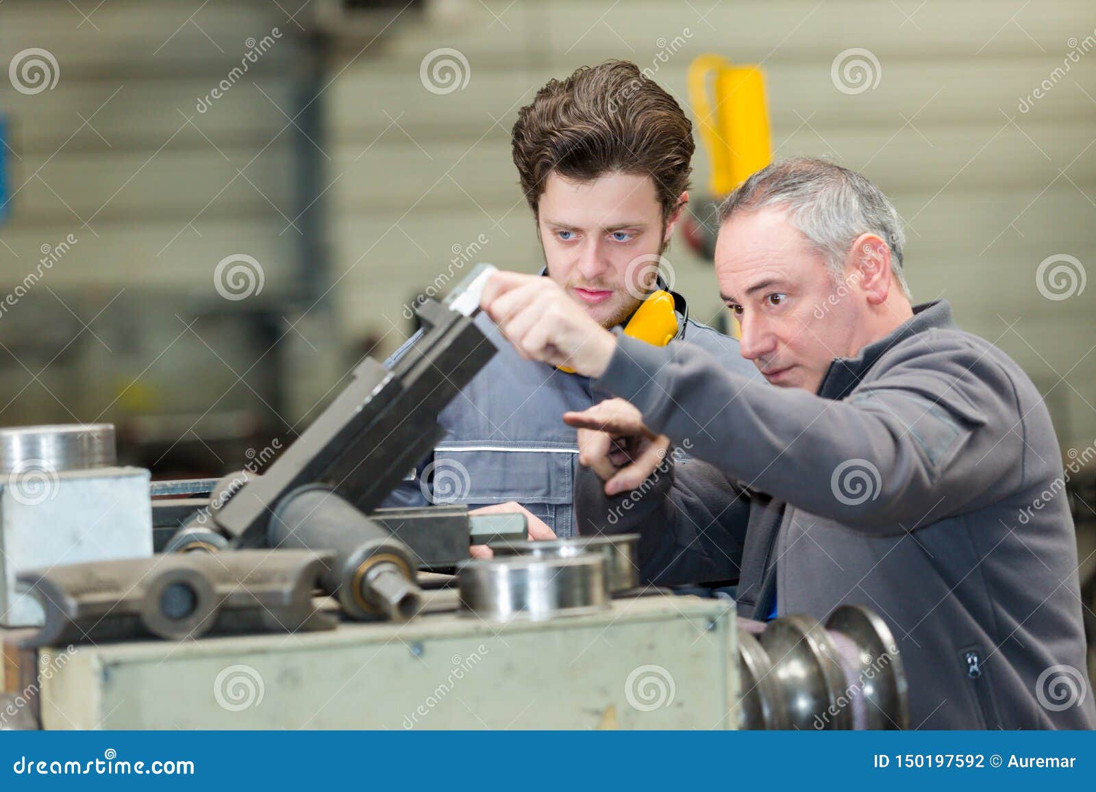 Supervisor Showing Industrial Equipment To Apprentice Stock Photo