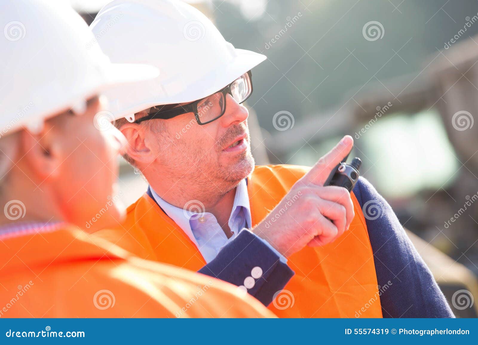 supervisor showing something to colleague at construction site