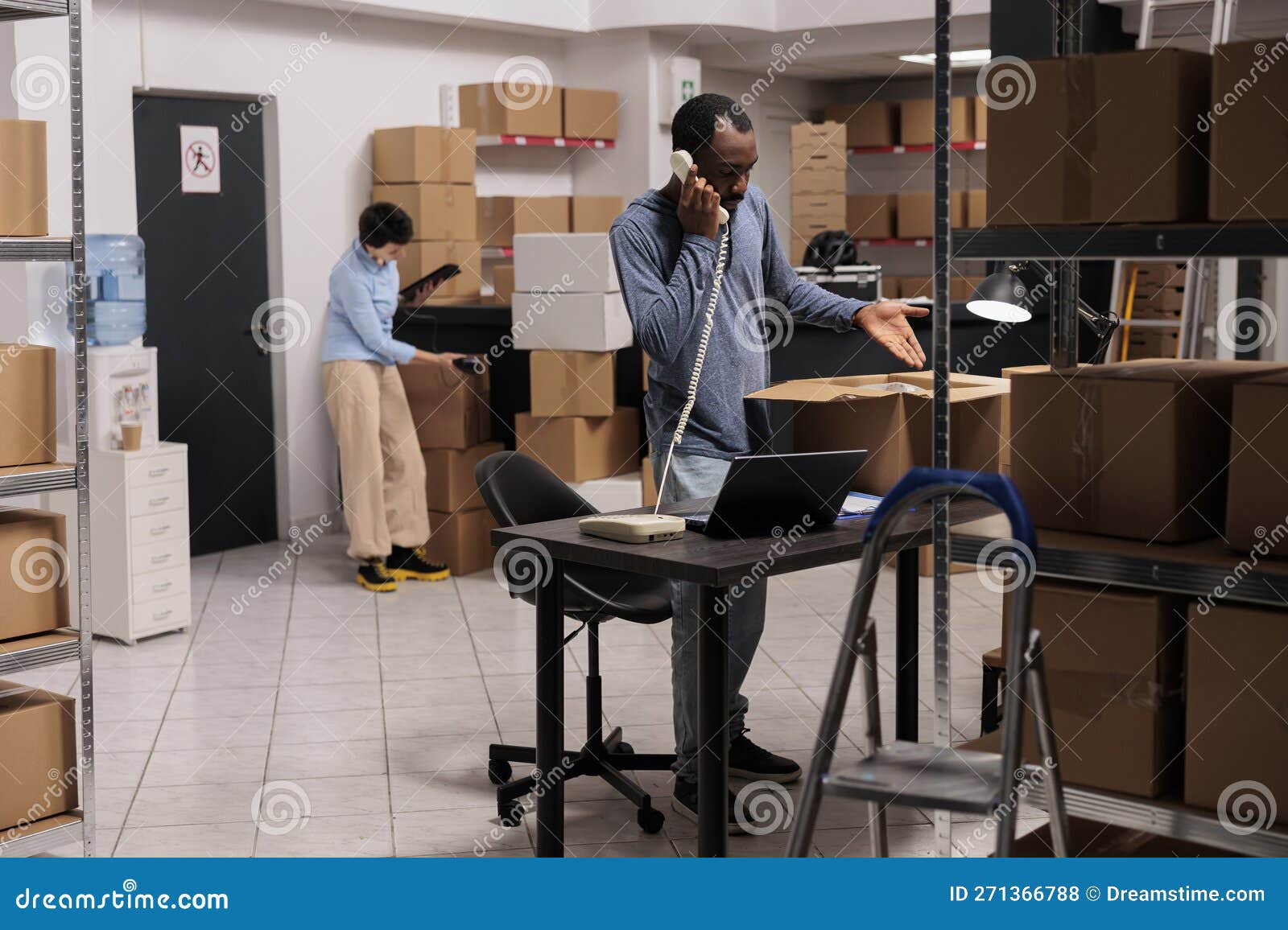 Supervisor Talking with Remote Warehouse Manager Using Landline Phone