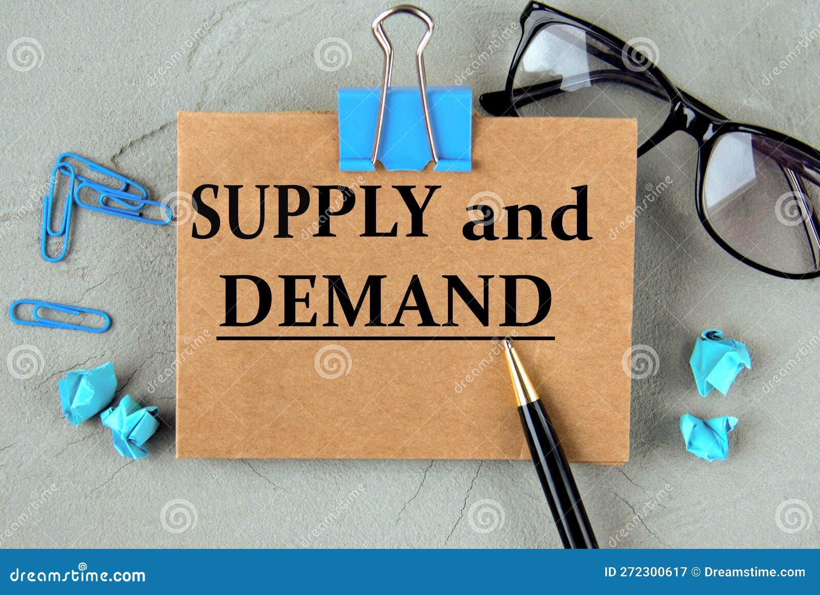 SUPPLY and DEMAND - Words on Brown Paper on the Background of Glasses, Pens and Paper Clips Stock Image