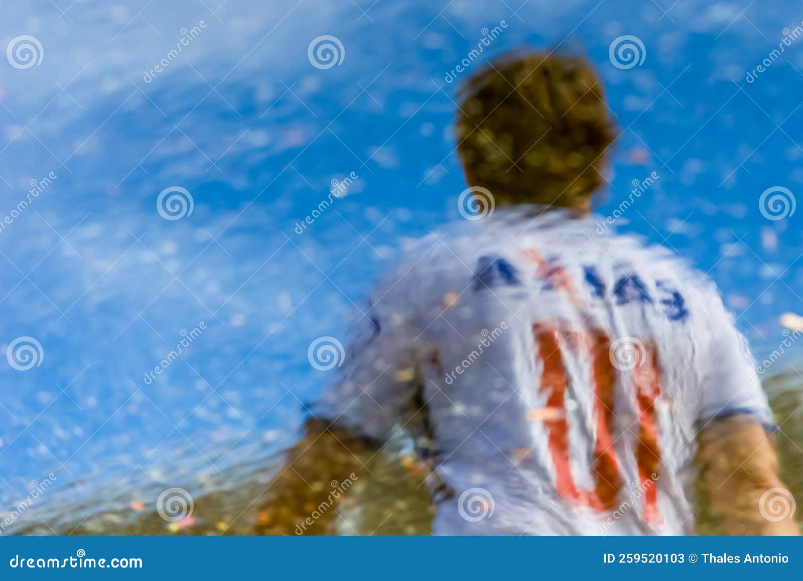 supporters of the esporte clube bahia football team, seen through the reflection of the water in the vicinity of the arena fonte