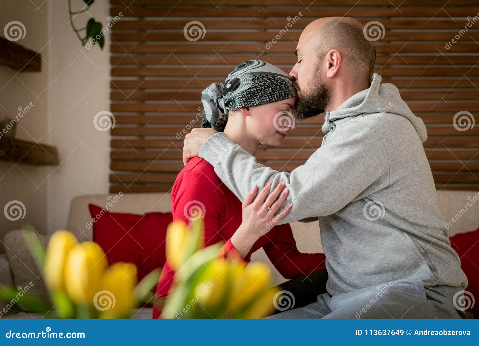 supportive husband kissing his wife, cancer patient, after treatment in hospital. cancer and family support.