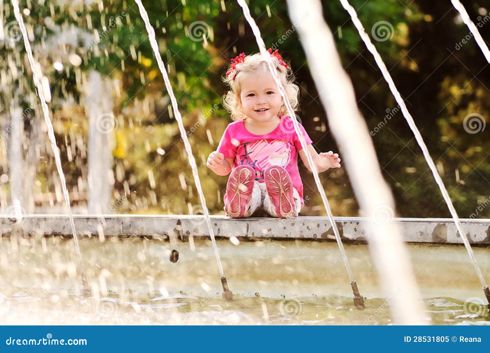 Fille d'enfant en bas âge sur la fontaine