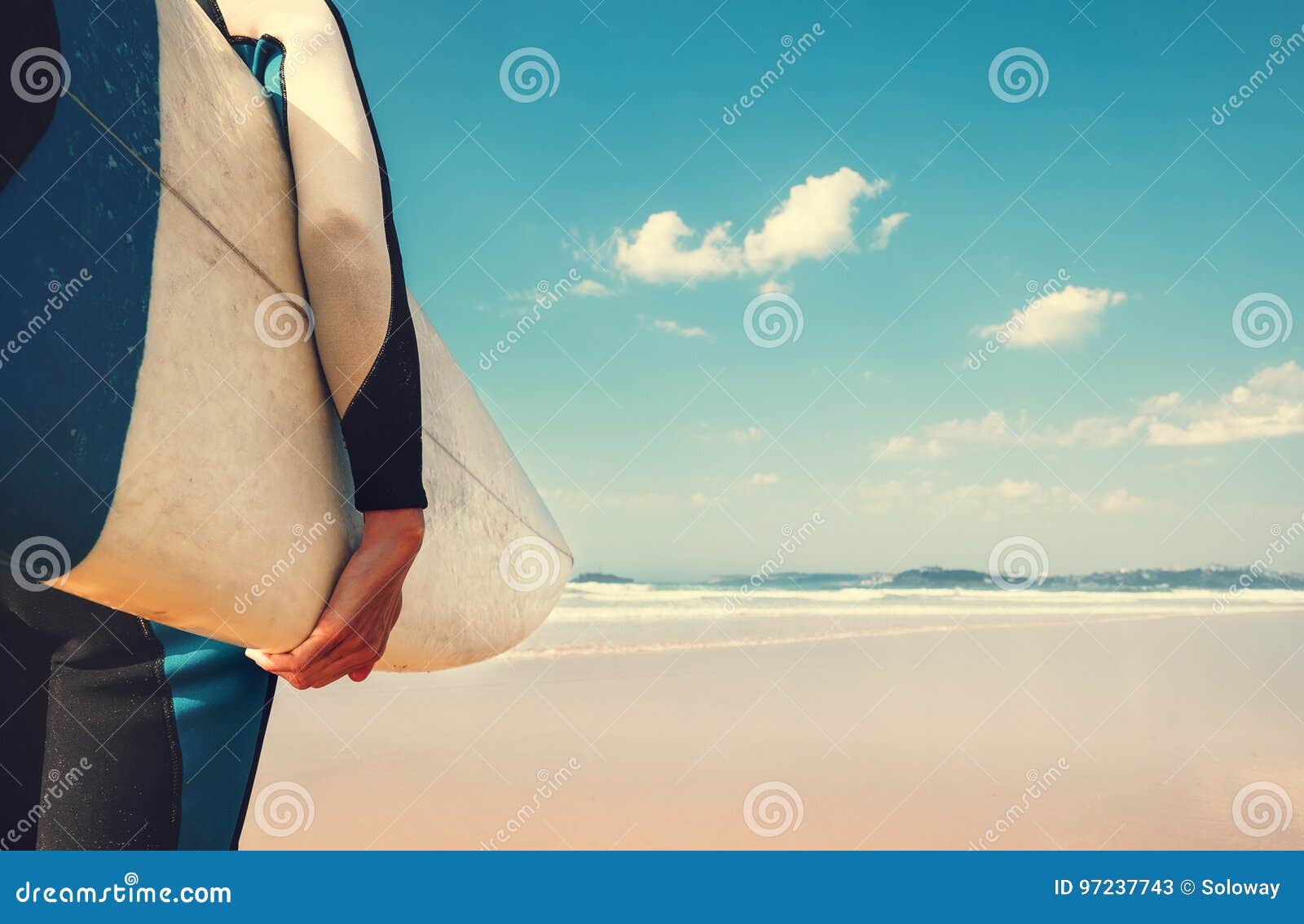surf board in surfer`s hand close up image with oceans waves vie