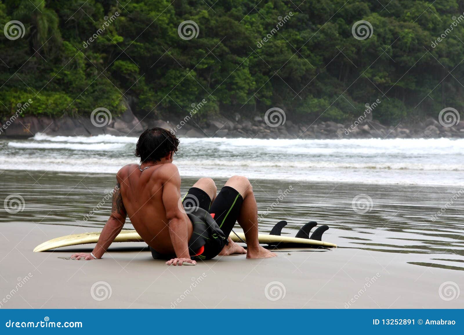 Surfer. Équipez le repos après avoir surfé sur une plage tropicale