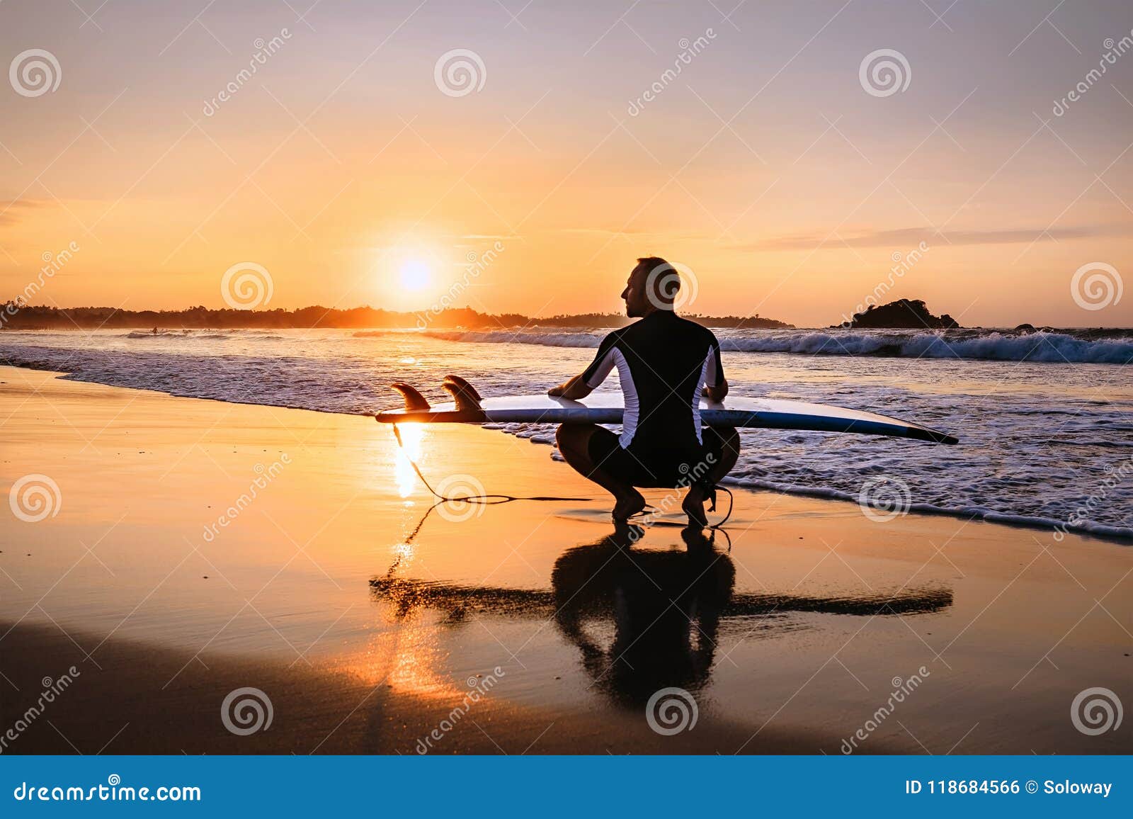 Surfer with Surfboard Sits on Ocean Surf Line at Sunset Time Stock ...