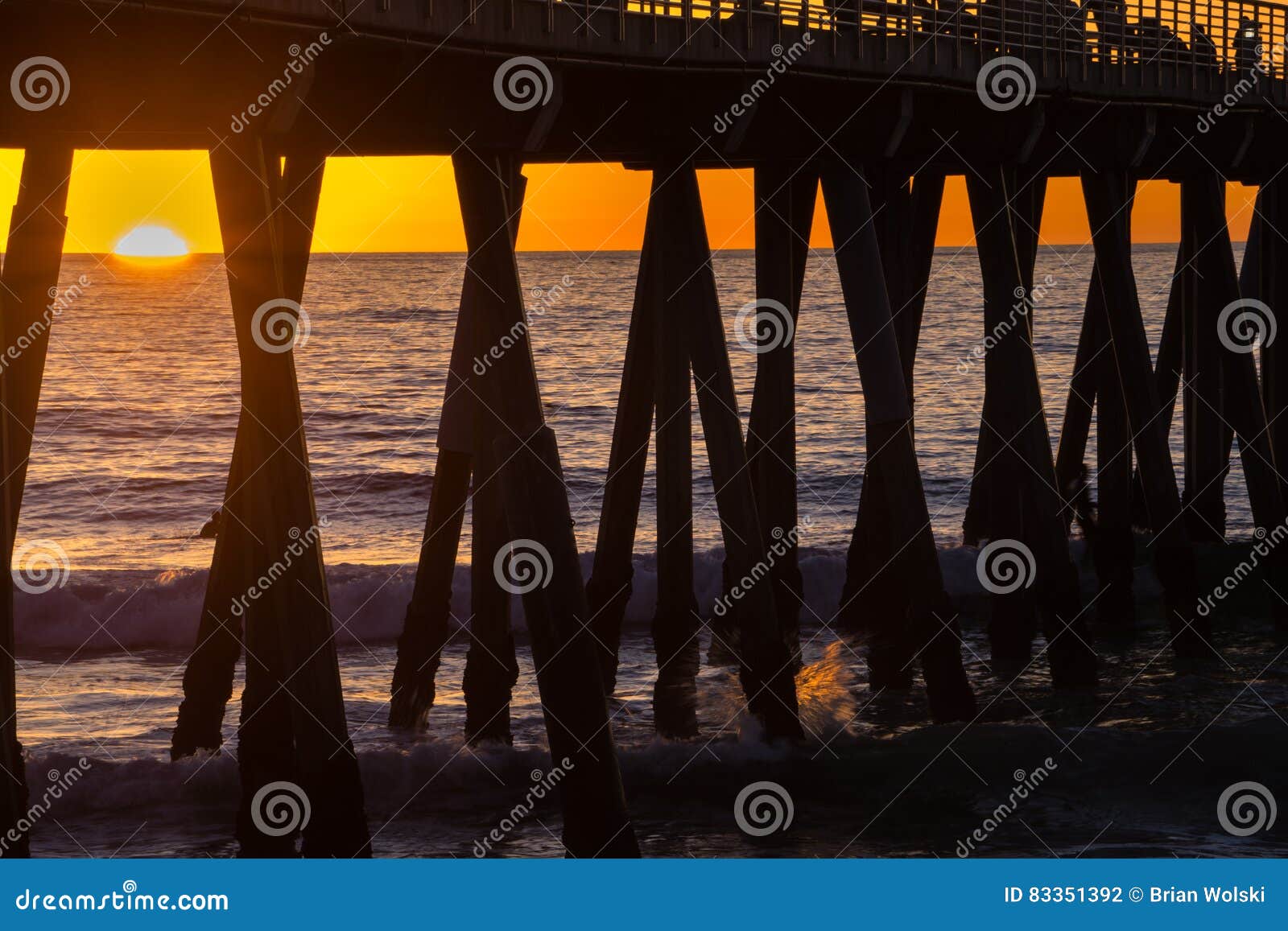 surfers under the hermosa beach pier