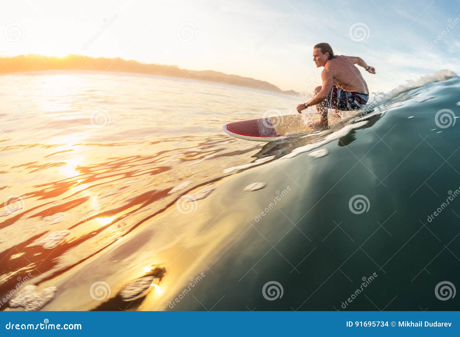 Surfingowiec przejażdżek fala. Surfingowiec jedzie perfect ocean fala przy wschodem słońca