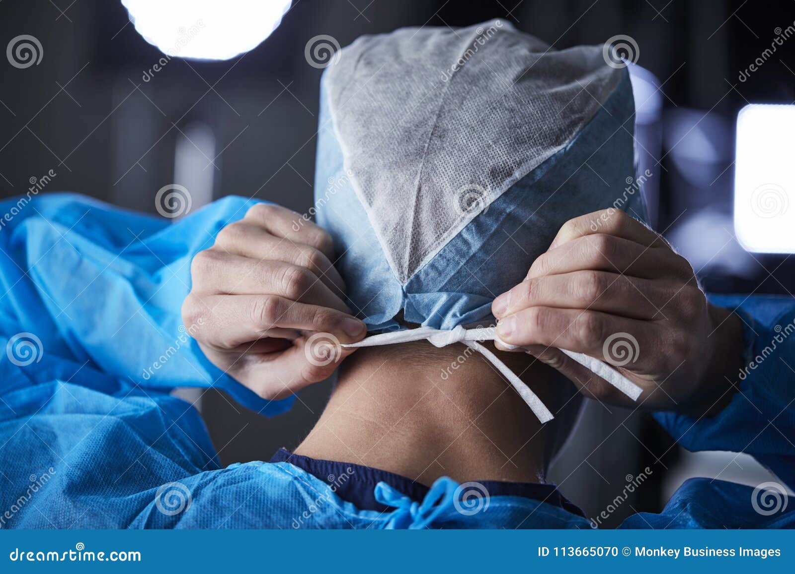 surgeon tying surgical cap in preparation, back view