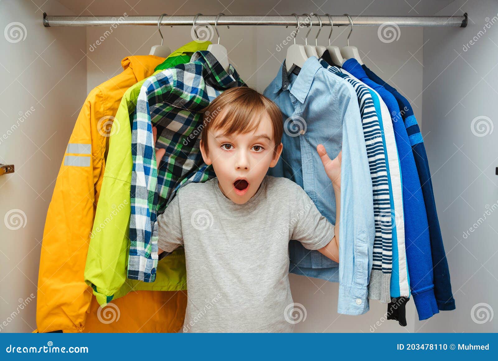 Surprised Cute Boy Searching for Clothing in a Closet. Preteen Boy ...