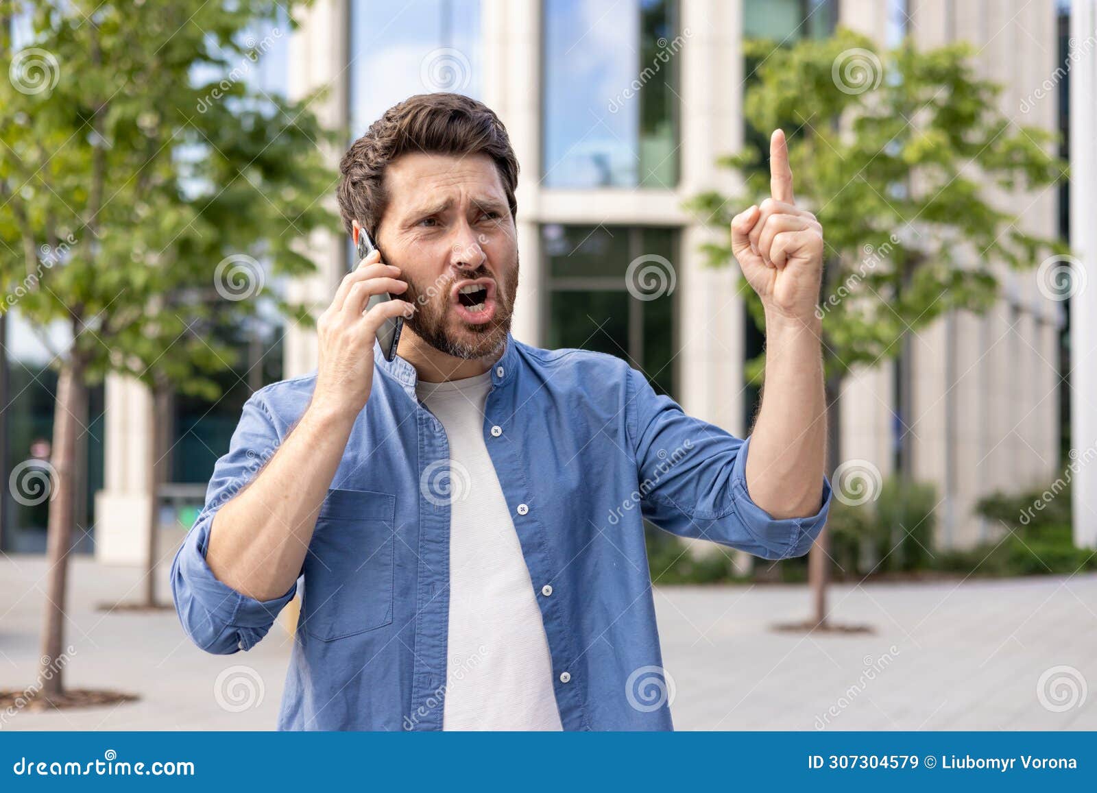 Bearded Businessman in Casual Attire Gesturing while on Phone Against ...