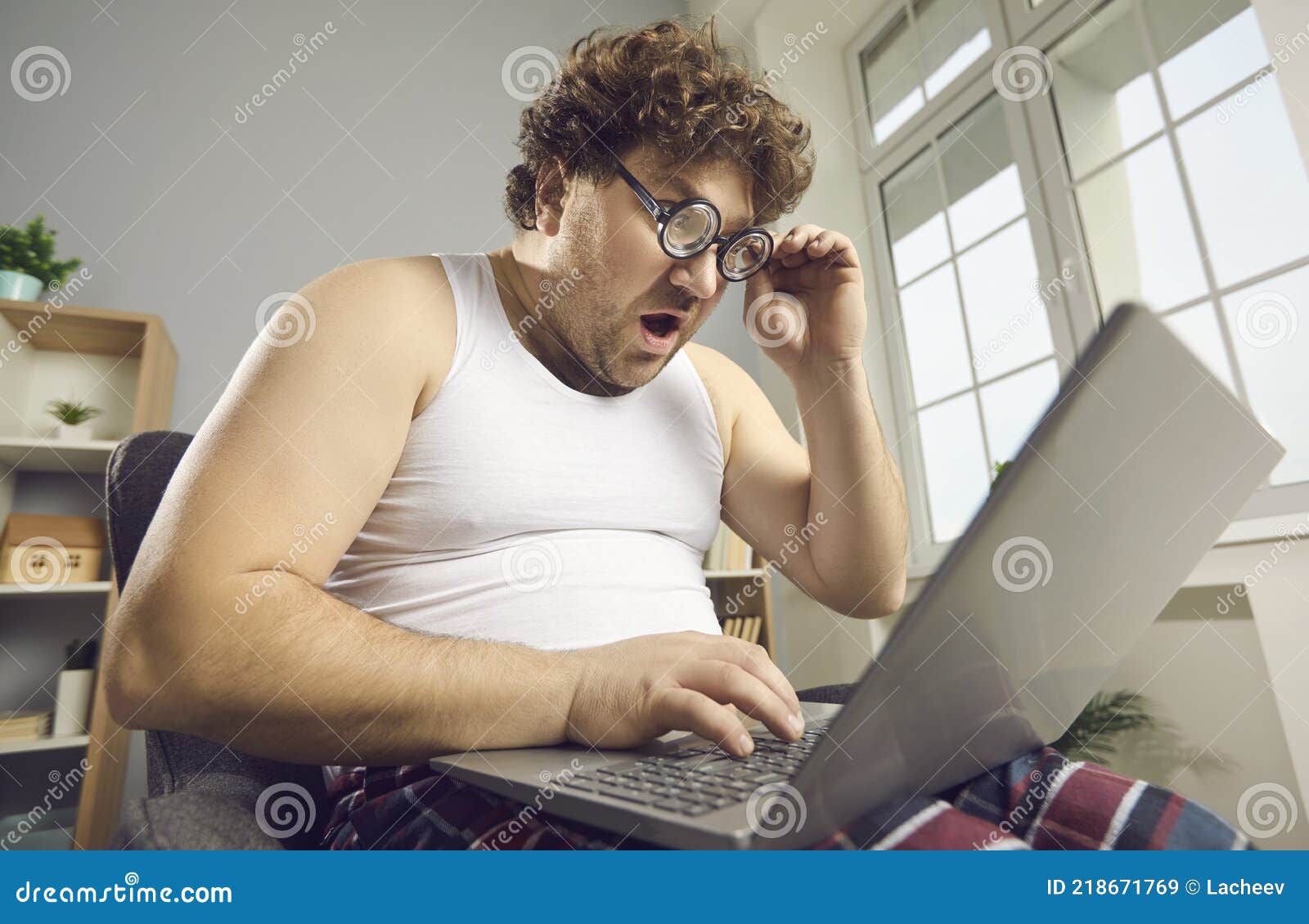 Astonished guy using internet work on computer from... 