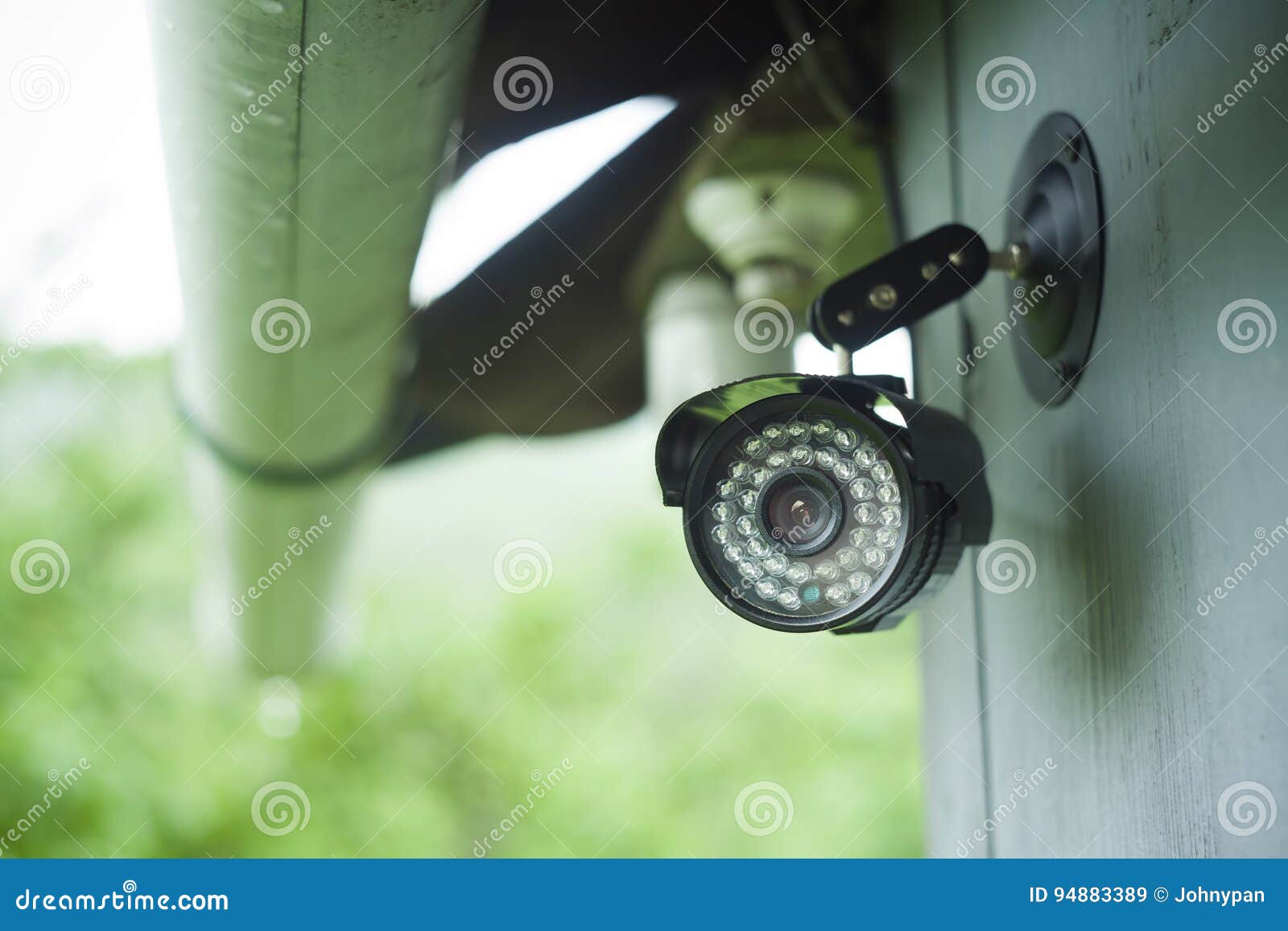 A Surveillance Camera Mounted On A Homemade Wooden Mount Hangs Over The