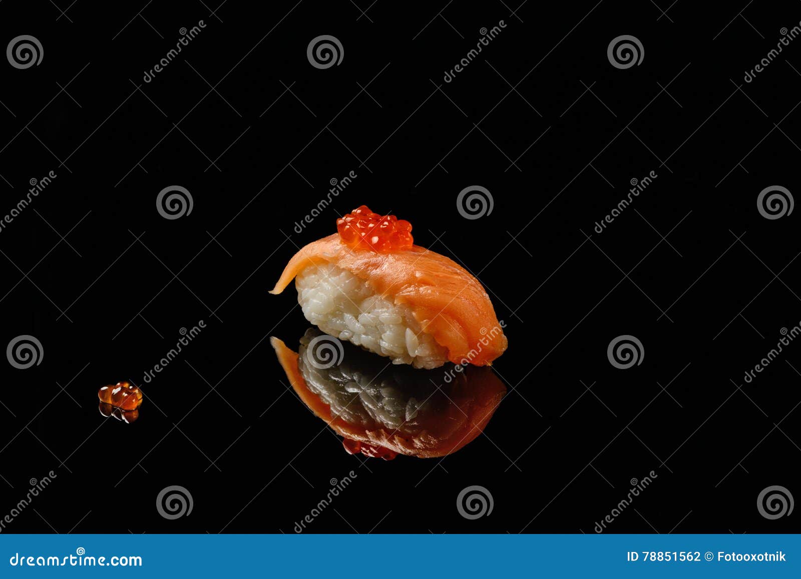 sushi and red caviar on black acryle with reflection