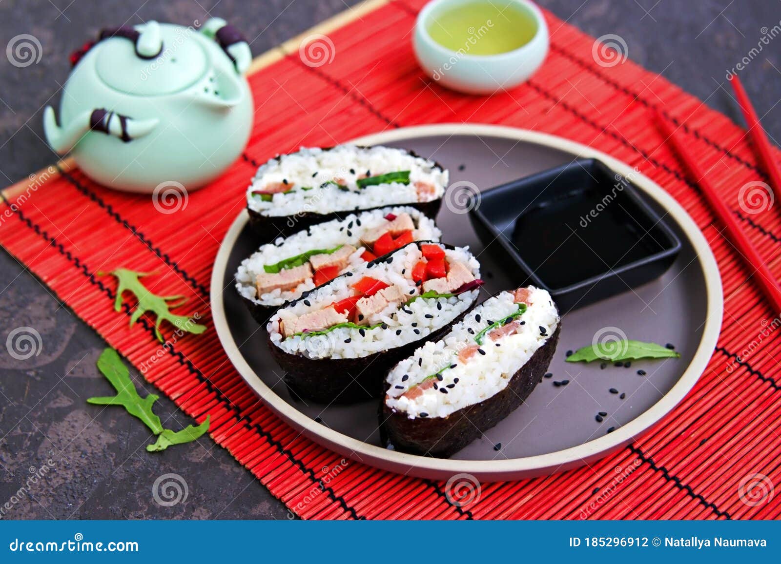 sushi sandwiches onigirazu with baked duck, spinach and sweet pepper on a brown clay plate