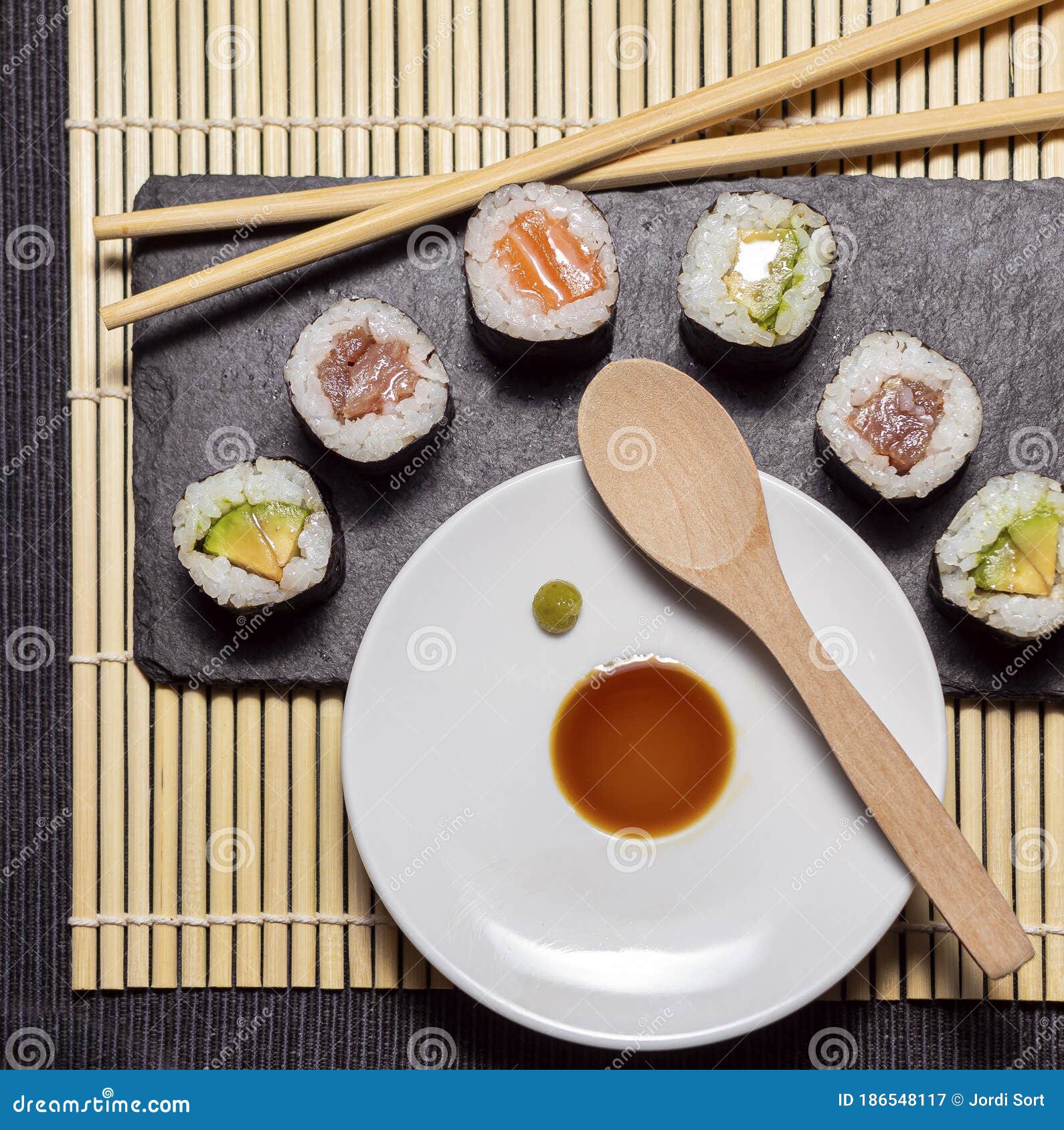 sushi slate table with chopsticks and hot sauce and soy sauce on bamboo rubber