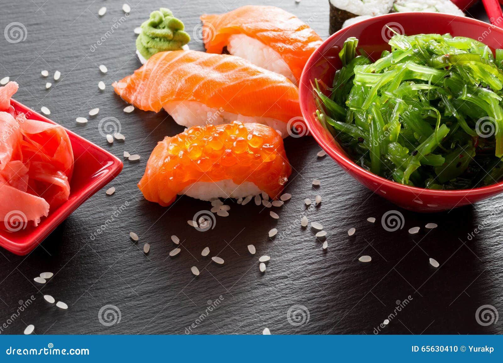 Sushi und grüner Meerespflanzensalat auf einer Schiefertabelle