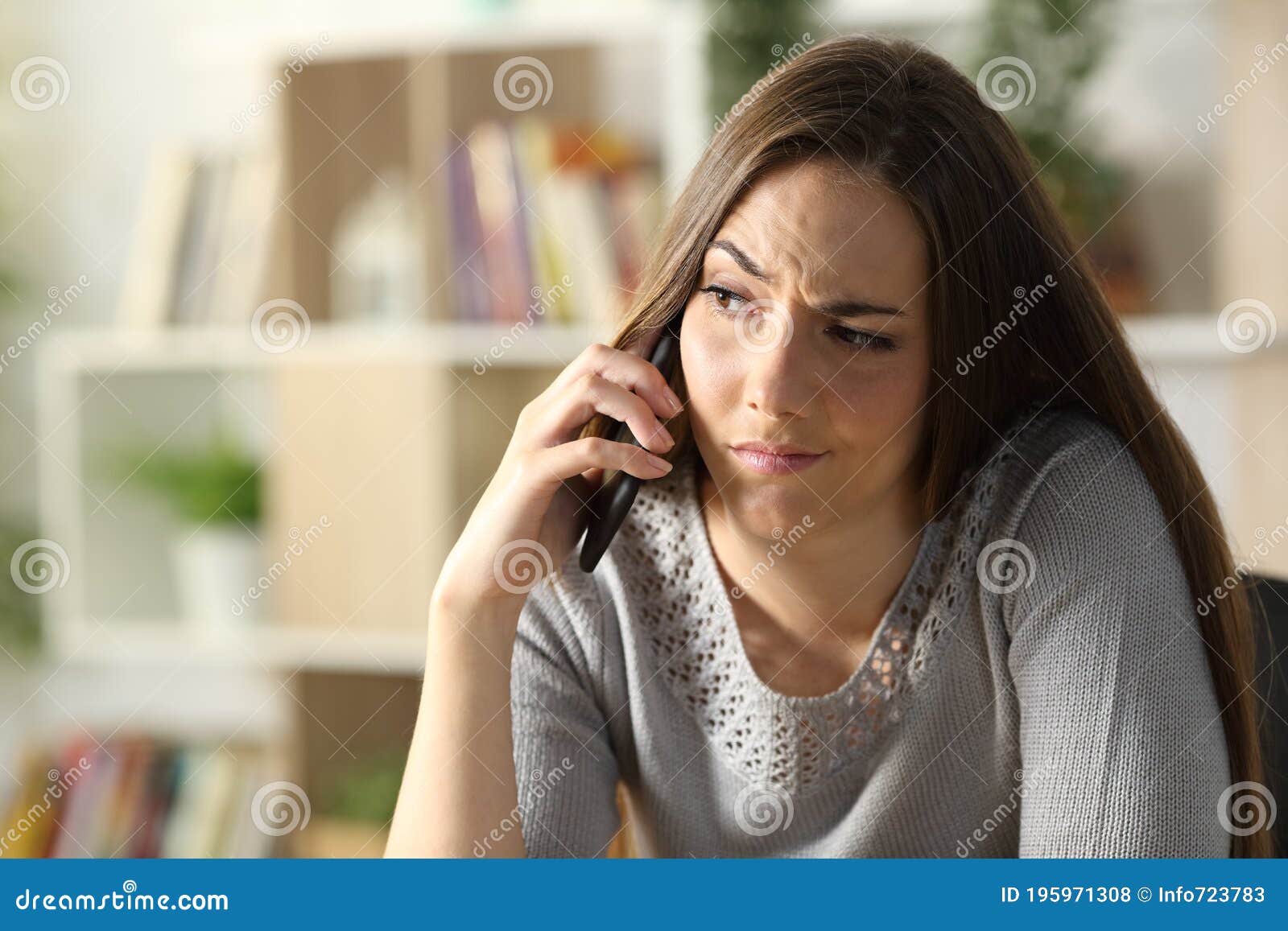 suspicious woman calling on phone sitting at home