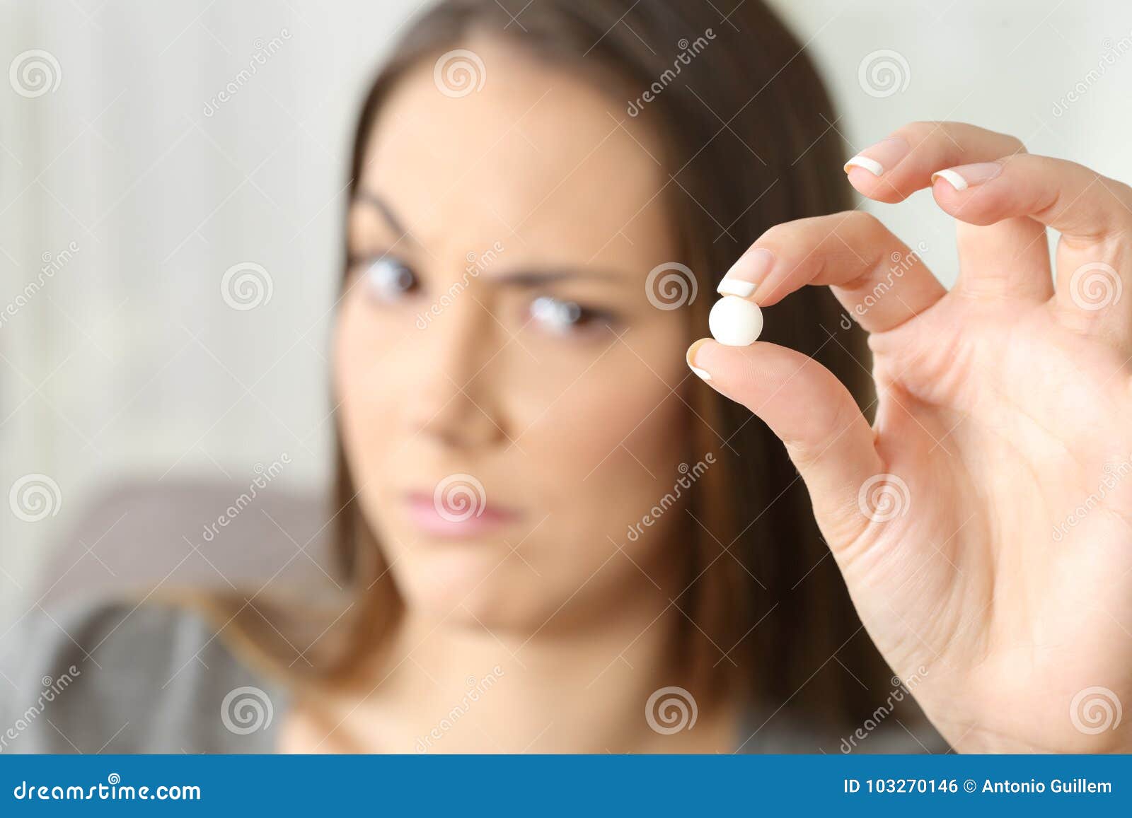 suspicious woman looking at a pill