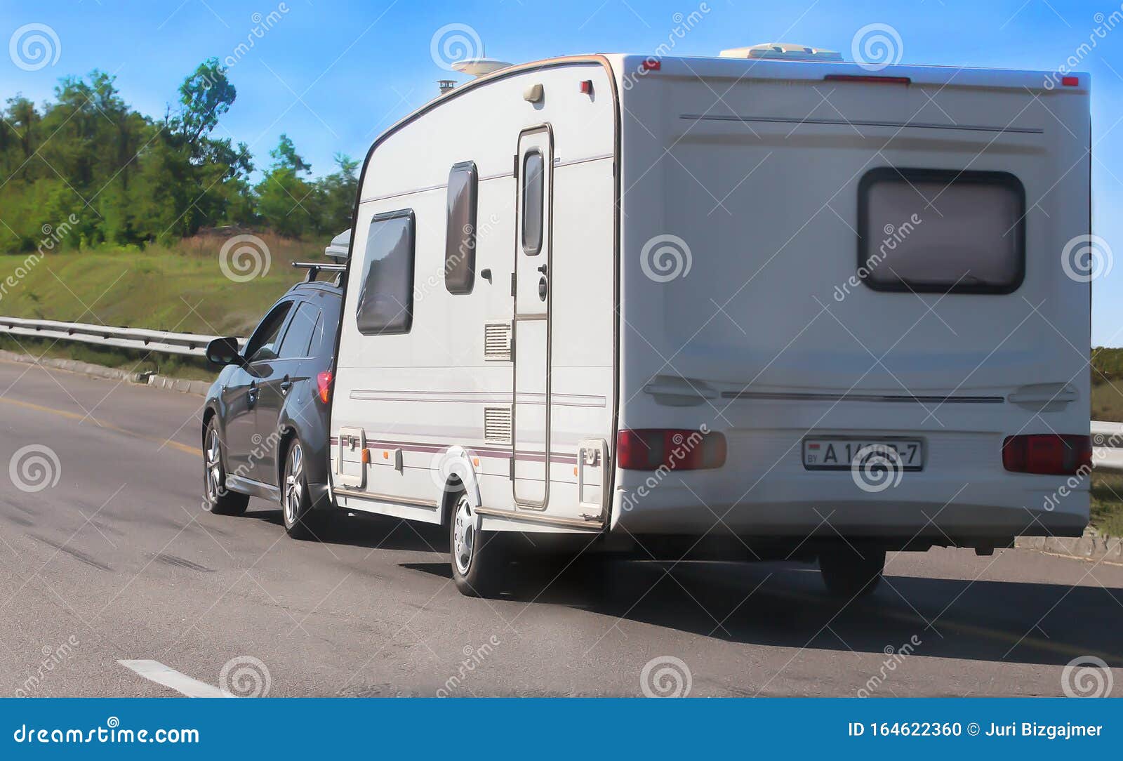 SUV with a Camping Trailer is Moving Along the Road Editorial Image