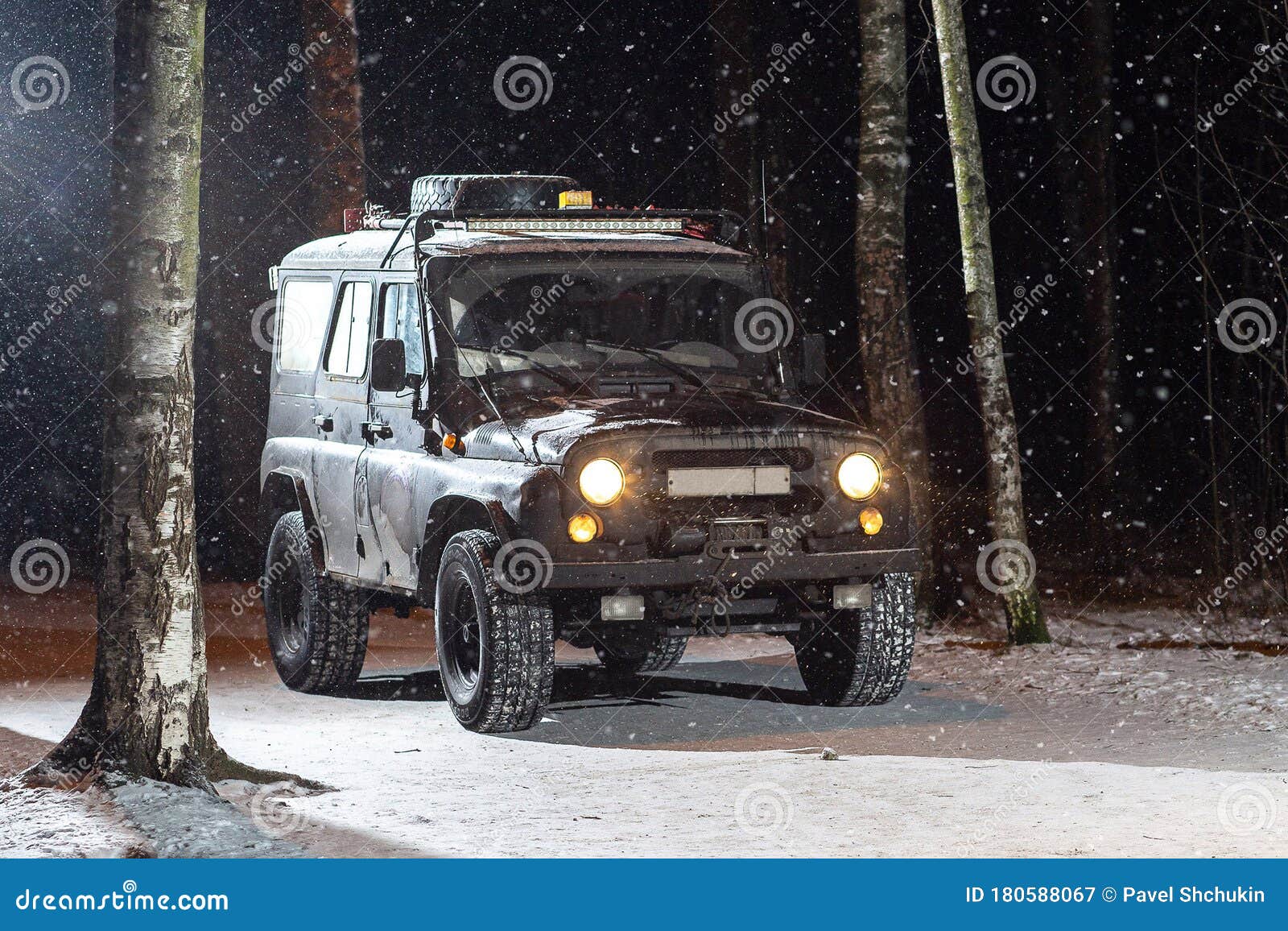 the suv is driving on a snowy night road