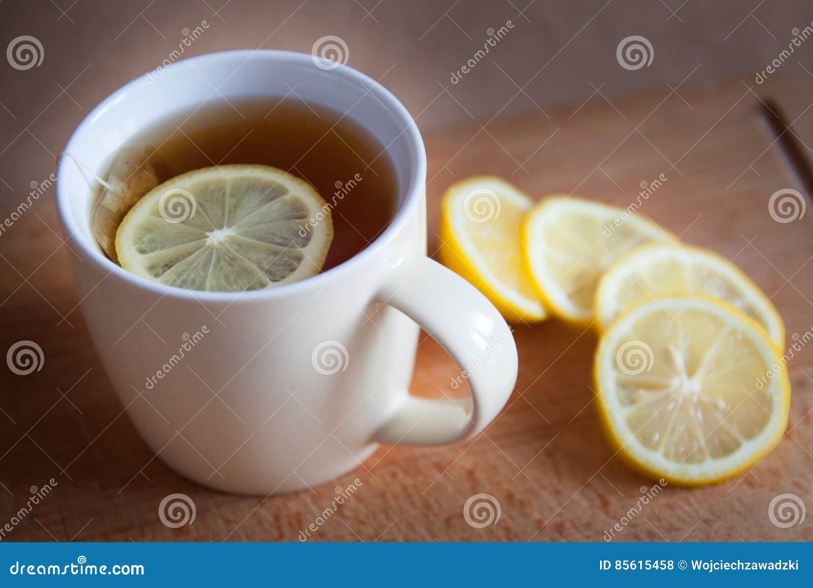 Svart tea med citronen. Svart te med citronen i den vita koppen och lamon på tabellen