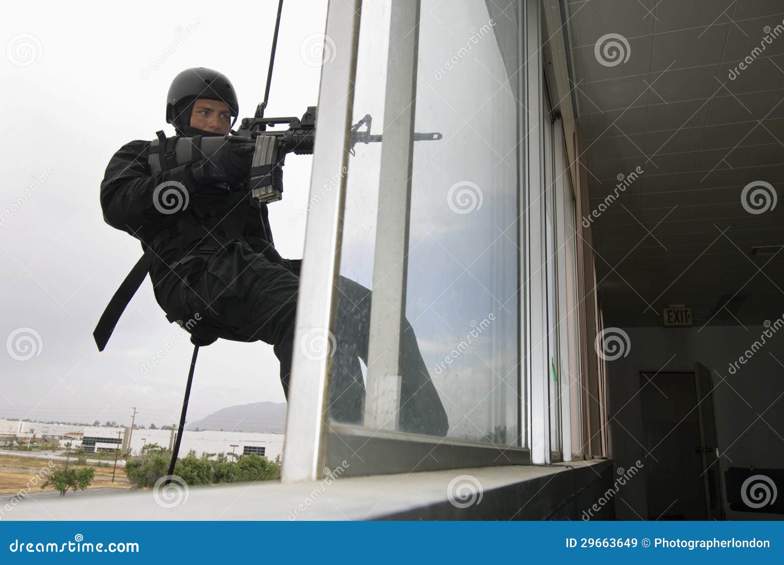 SWAT Team Officer Rappelling and Aiming Gun Stock Image - Image of